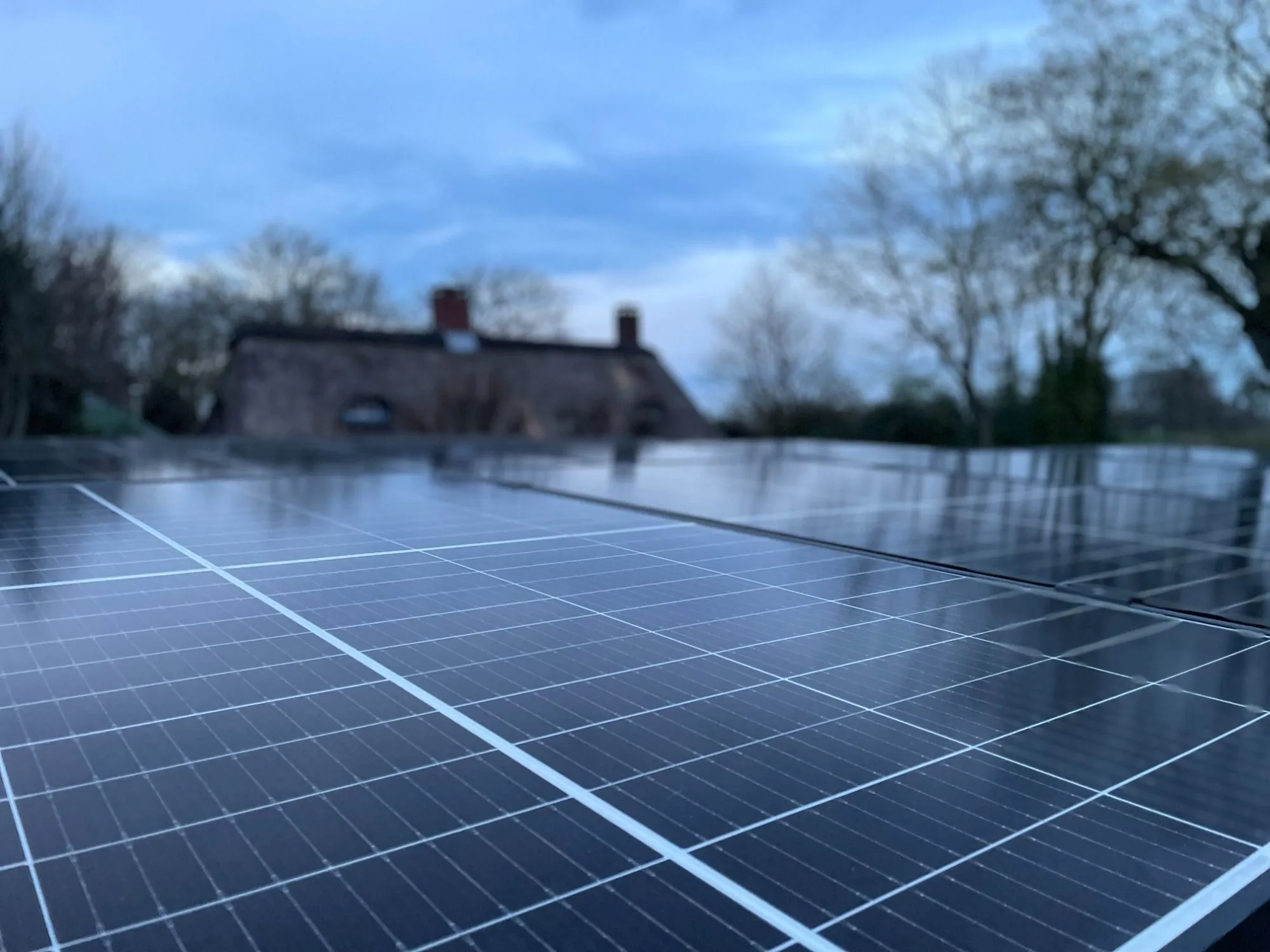 Aufgeständerte Photovoltaikmodule auf einem Carport in der Dämmerung
