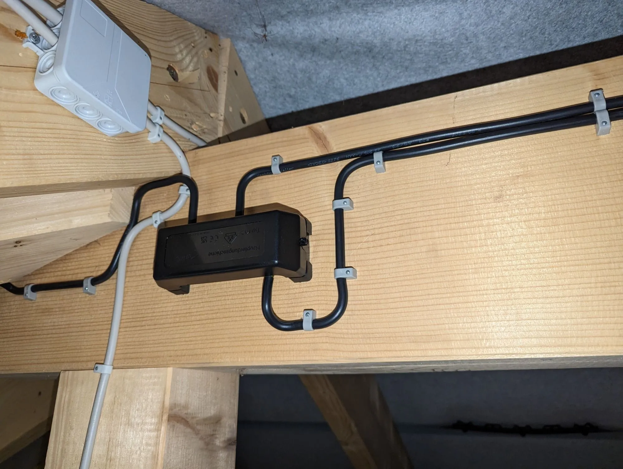 Abzweigdose und Kabelführung auf einem Dachsparren im Dachstuhl